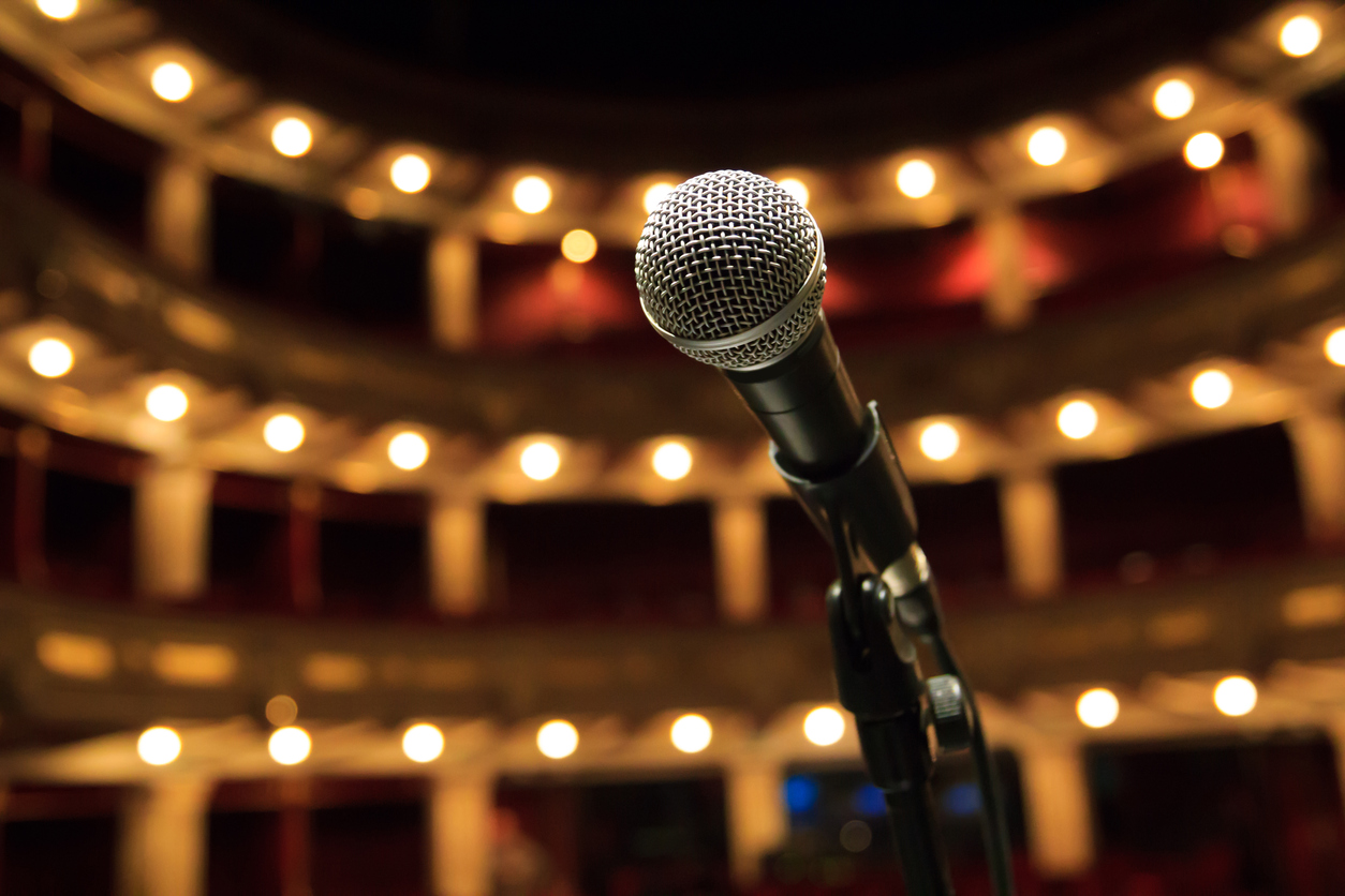 Stage microphone lit by the house lights of a theatre